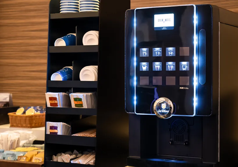 ロビーに設置された、カップやティーバッグが用意されたセルフのコーヒーマシンとドリンクコーナー。