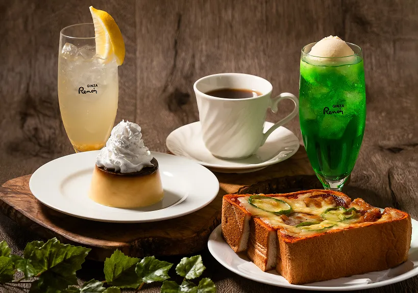 テーブルに並ぶ、レモンスカッシュ、クリームソーダ、コーヒー、ケーキ、ピザトーストの喫茶メニュー。