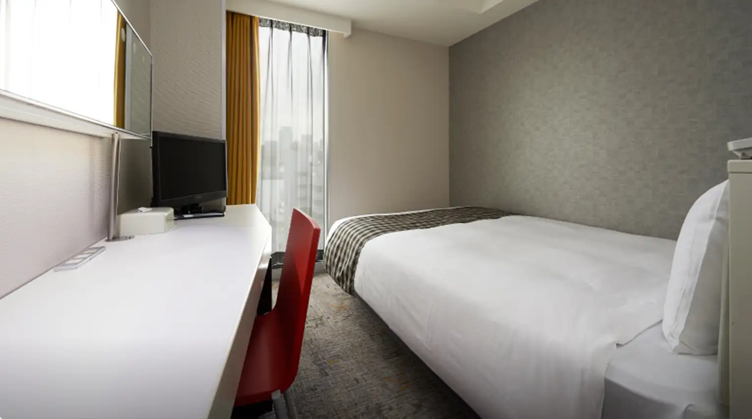 ダブルベッドが設置された清潔感のある客室