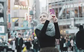 観光地の街中で写真を撮る人物の様子